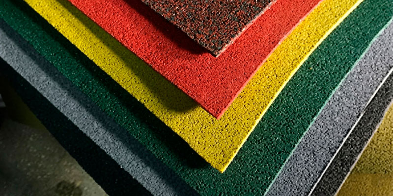 Shock-absorbing rubber tiles and durable surfaces for playgrounds and sports facilities